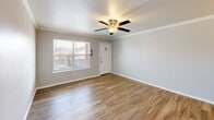 Located in Dallas, TX along LBJ Freeway, this one-bedroom, one-bathroom residence offers a thoughtfully designed single-floor layout. The open-concept living, dining, and kitchen area is anchored by warm wood-look flooring and accented with crown molding throughout. A ceiling fan with light kit and a window providing natural light complete the welcoming living space, while a decorative chandelier adds a touch of elegance to the dining area.

The galley-style kitchen features dark espresso cabinetry, stone-look countertops, a stainless steel refrigerator, and an electric range, offering ample counter and storage space in a compact, efficient footprint.

The generously sized primary bedroom is finished with plush carpeting, a ceiling fan, and two arched windows that bring in natural light and views of the surroundings. Two closets provide substantial storage throughout the unit.

The bathroom is well-appointed with a tiled tub-shower combination featuring a built-in niche, a granite-topped vanity with dark wood cabinetry, and wood-look flooring that ties seamlessly to the rest of the home. A hallway connects the living areas to the private spaces, completing this efficiently organized and comfortable residence.