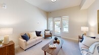 Located at 100 Glenwood Circle in Monterey, California, this thoughtfully designed 2-bedroom, 1-bathroom single-floor residence offers a comfortable and functional layout. The welcoming hallway entry features light wood-style flooring and warm neutral walls, setting a calm tone throughout. The open kitchen stands out with its gray shaker-style cabinetry, white quartz countertops, stainless steel appliances including a French door refrigerator and dishwasher, and pendant lighting that adds a modern touch. Light flooring carries through the kitchen, enhancing its bright, airy feel. The living room offers plush carpeting, elevated ceilings, and a glass door opening directly to the outdoors, filling the space with natural light. The spacious primary bedroom includes carpeted floors, a closet, and a serene, neutral palette. The second bedroom also features carpet, natural light, and direct outdoor access via a glass door. The bathroom is finished with full-height tile wainscoting, grab bars for accessibility, and clean tile flooring. A dedicated laundry room houses a full-size washer and dryer alongside built-in cabinetry with a countertop workspace. Three closets provide ample storage throughout the home.