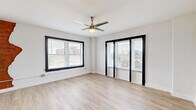 Located at 511 Maple Blvd in Kansas City, MO, this well-appointed one-bedroom, one-bathroom unit offers a thoughtfully designed single-floor layout. Light hardwood-style flooring runs throughout, tying the space together with a clean, contemporary feel.

The combined kitchen and living area serves as the heart of the unit. The kitchen is equipped with gray flat-front cabinetry, dark countertops, stainless steel appliances including a dishwasher and refrigerator, a gas range, and an over-the-range microwave. A movable kitchen island with a butcher block top adds flexible prep and storage space.

The living area benefits from large windows framed in bold black trim, which invite abundant natural light and offer views of the surrounding Kansas City skyline and neighborhood. A ceiling fan with a brushed metal finish adds both style and comfort to the space.

The bedroom is a cozy, well-lit room featuring a window with blinds and baseboard heating. A dedicated laundry area houses an in-unit washer, providing everyday convenience. The bathroom features a walk-in shower with a white surround, a modern vanity with a dark wood finish, a black matte faucet, and wood-look flooring, completing the unit's cohesive modern aesthetic.