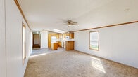 Located at 2600 University Ave in Williston, North Dakota, this single-floor, 3-bedroom, 2-bathroom home offers a functional and well-organized layout. The open-concept living and dining area flows directly into the kitchen, creating a spacious, connected feel. The living room features neutral carpet, a ceiling fan, and sliding glass doors that invite natural light. The kitchen is well-appointed with warm honey-toned oak cabinetry, a central island, skylights, wood-look flooring, and white appliances including a gas range, refrigerator, and dishwasher. A second kitchen view reveals ample upper and lower cabinet storage with a double sink and window. The three bedrooms are carpeted and bright, each with closet access and windows that bring in natural light; the primary bedroom includes a ceiling fan. The primary bathroom features a sliding glass shower enclosure, a skylight, oak vanity with countertop sink, and wood-look flooring. The second bathroom includes a clean tub-shower combo. Additional spaces include a laundry area, hallway, and three closets. Crown molding with warm wood accents trims the walls throughout, adding a consistent, cohesive finishing touch to the entire home.