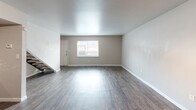 Located in Fort Worth, TX, this two-story home offers a practical and functional layout spread across two floors. The ground floor features an open-plan living, dining, and kitchen area with rich, dark hardwood-style flooring that runs throughout. The living area is bright and airy, with a window allowing natural light to fill the space, while the kitchen is equipped with a full-size refrigerator. A textured accent wall adds a warm, earthy tone to this main gathering space. Both bathrooms are well-appointed with tiled tub-and-shower combinations, wood-look flooring, and overhead cabinetry for storage. One bathroom also features a vanity with a light-colored countertop and a framed mirror. The upper floor houses both bedrooms, including a generously sized primary bedroom that offers ample space for a full bedroom suite. Both bedrooms are finished with plush carpet and feature ceiling fans with lighting fixtures, exposed beam-style detailing, and windows that bring in natural light. The secondary bedroom also features hardwood-style flooring. With four closets distributed throughout the home, storage is plentiful. Staircases connect both levels, and a hallway provides a smooth flow between upper-floor rooms.