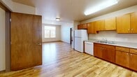 Located at 455 N Burlington Ave in Lafayette, Colorado, this single-floor, 2-bedroom, 1-bathroom residence offers a functional and well-organized layout. Light hardwood flooring flows consistently throughout the space, creating a cohesive and clean aesthetic.

The open-concept kitchen and living area form the heart of the home. The kitchen is outfitted with warm wood cabinetry, a white refrigerator, dishwasher, and electric range, along with ample counter space and an under-cabinet sink. Natural light enters the living area through a window with exterior views, enhancing the bright, airy feel of the shared space.

The primary bedroom features a built-in window seat with outdoor views, providing a charming nook, along with a sliding wood closet. The second bedroom also includes a sliding wood closet and a window with natural light. Both rooms benefit from elevated ceilings that add a sense of openness.

The bathroom is equipped with accessibility features, including grab bars near the toilet and shower area, a wood-toned vanity with sink, and matching hardwood flooring. Additional storage is provided through four closets distributed throughout the unit, and a dedicated laundry room adds everyday convenience. The overall ambiance is clean, neutral, and move-in ready.