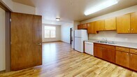 Located at 455 N Burlington Ave in Lafayette, Colorado, this single-floor, 2-bedroom, 1-bathroom residence offers a functional and well-organized layout. Light hardwood flooring flows consistently throughout the space, creating a cohesive and clean aesthetic.

The open-concept kitchen and living area form the heart of the home. The kitchen is outfitted with warm wood cabinetry, a white refrigerator, dishwasher, and electric range, along with ample counter space and an under-cabinet sink. Natural light enters the living area through a window with exterior views, enhancing the bright, airy feel of the shared space.

The primary bedroom features a built-in window seat with outdoor views, providing a charming nook, along with a sliding wood closet. The second bedroom also includes a sliding wood closet and a window with natural light. Both rooms benefit from elevated ceilings that add a sense of openness.

The bathroom is equipped with accessibility features, including grab bars near the toilet and shower area, a wood-toned vanity with sink, and matching hardwood flooring. Additional storage is provided through four closets distributed throughout the unit, and a dedicated laundry room adds everyday convenience. The overall ambiance is clean, neutral, and move-in ready.