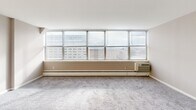 Located at 660 Boas St in Harrisburg, PA, this efficient single-floor studio offers a well-organized layout that makes smart use of its compact footprint. The living area is a highlight of the space, featuring a wide bank of multi-pane windows that span nearly the full width of the room, flooding the interior with natural light and offering open views of the surrounding Harrisburg cityscape. Soft carpeting and a wall-mounted HVAC unit complete the living space.

The galley-style kitchen is thoughtfully equipped with white cabinetry extending to the ceiling for ample storage, a light-toned countertop with a double stainless steel sink, a gas range with overhead ventilation, and a full-size refrigerator. Light hardwood-style flooring adds a clean, modern touch to the kitchen area.

The bathroom features a retro aesthetic with distinctive sky-blue square tile lining the walls and surrounding a built-in bathtub, complemented by a toilet and a countertop with an integrated sink. A dedicated closet provides additional storage. The overall layout is practical and efficient, making this a well-appointed urban unit in the heart of Pennsylvania's capital city.