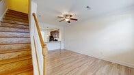 Located at 100 Dalton Lane in Charlottesville, Virginia, this three-floor residence offers a well-organized layout across three distinct levels, featuring 3 bedrooms, 4 bathrooms, two kitchens, and two living areas. The ground floor provides an entry point into bright, open living and kitchen spaces, with light wood-look flooring, crisp crown molding, and ceiling fans throughout the main areas. The kitchen is equipped with stainless steel appliances, rich dark cabinetry, granite-style countertops, and a sliding glass door that opens to an outdoor patio with views of a fenced backyard. The main living area on this floor is bathed in natural light from large windows, creating an airy, welcoming atmosphere. Staircases with classic wood banisters connect all three floors. The upper levels house the bedrooms, which feature plush carpeting, ceiling fans, and ample closet space with louvered doors. The spacious primary bedroom offers a generous footprint for comfortable living. The four bathrooms are consistently finished with dark wood vanities, granite countertops, and wood-look tile flooring—some featuring full tub-shower combinations. The top floor provides a more intimate setting with a compact, functional layout. Overall, the home presents a clean, neutral palette throughout, making it a versatile and move-in ready residence.