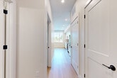 Located at 4225 E Hale Pkwy in Denver's desirable Park Hill neighborhood, this well-designed one-bedroom, one-bathroom unit offers a clean, modern aesthetic across its efficiently planned single floor. Light-toned hardwood flooring runs throughout, creating a bright and cohesive feel from room to room.

The open-concept living, dining, and kitchen area serves as the heart of the unit. The kitchen is appointed with sleek flat-front white cabinetry extending to the ceiling, a herringbone-patterned tile backsplash, stainless steel appliances including a dishwasher, range, and built-in microwave, and a single-basin sink. A large window floods the dining area with natural light and offers pleasant views of the surrounding tree-lined neighborhood.

A well-organized hallway connects the living areas to the private spaces, lined with shaker-style doors featuring matte black hardware that provide access to closets, a pantry, and an in-unit laundry area. The bedroom is a comfortable, quiet retreat with light-filled windows, light wood floors, and a double-door closet with matching shaker styling.

The bathroom features large-format neutral tile on both the floor and tub surround, a soaking tub with overhead shower, and a clean white vanity, delivering a calm and functional space.