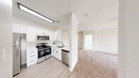 Located at 7401 W Washington Ave in Las Vegas, NV, this well-appointed two-bedroom, two-bathroom residence offers a thoughtfully designed single-floor layout. The open-concept kitchen is outfitted with white shaker cabinetry, a classic subway tile backsplash, stainless steel appliances including a range, microwave, and dishwasher, and light wood-style flooring. It flows naturally into the spacious carpeted living room, which features crown molding, a ceiling fan, a corner fireplace, and a sliding glass door that fills the space with natural light and provides outdoor access. Both bedrooms are generously sized, carpeted, and equipped with ceiling fans and windows fitted with vertical blinds that allow ample natural light. The primary bathroom features a white vanity with chrome hardware and a shower/tub combo with sliding glass doors. The second bathroom mirrors this clean aesthetic with a tub/shower combination, white vanity, and light wood-style flooring. A dedicated laundry room with a water heater adds everyday convenience. Throughout the residence, a consistent neutral color palette, white trim, and modern fixtures create a bright, cohesive, and move-in-ready environment.