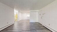 Located at 33 Kenneth St in West Haven, Connecticut, this one-bedroom, one-bathroom unit offers a practical and well-organized single-floor layout. Throughout the space, light gray luxury vinyl plank flooring provides a clean, modern look, complemented by crisp white walls and baseboard heating units along the perimeter.

The open living and kitchen area forms the heart of the unit. The living room receives generous natural light through a large sliding glass door that opens to a view of green outdoor space, creating a bright and airy atmosphere. The kitchen is efficiently designed with white cabinetry, light countertops, a white range, and a full-size refrigerator, providing ample storage and functionality.

The bedroom is a well-proportioned room featuring a window with natural light, a dedicated closet, and continued LVP flooring, offering a quiet and comfortable retreat. A separate closet provides additional storage conveniently accessible from the main living area.

The bathroom features classic yellow ceramic tile on the walls and surrounding the full-size soaking tub, along with a white vanity. The unit's entry opens directly into the main living space, with a double-panel closet door just inside the front entrance for added convenience.