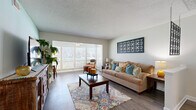 Located in Clearwater, FL, this single-floor 2-bedroom, 2-bathroom residence offers a well-designed layout that maximizes comfort and functionality. The living room welcomes with warm wood-look flooring, soft aqua accent walls, and natural light streaming through large windows with plantation shutters, creating a bright and inviting atmosphere. An open connection flows into the dining area, which features the same flooring and a pass-through view into the kitchen, making it ideal for everyday living and entertaining.

The kitchen is equipped with white cabinetry, dark countertops, white appliances including a dishwasher, and a convenient in-unit laundry area tucked behind louvered doors. The dining space adjacent to the kitchen provides a cozy setting with direct sightlines to the living area.

The primary bedroom is generously sized with plush carpet, a large louvered double-door closet, and a window that brings in natural light. The second bedroom offers similar comfort and storage. Both bathrooms are finished with wood-look flooring, white vanities with single-sink basins, large mirrors, and tub-shower combinations.

A hallway connects the private areas of the home, and the overall layout is efficiently organized for comfortable day-to-day living in a relaxed Florida setting.