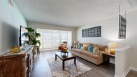 Located in Clearwater, FL, this single-floor 2-bedroom, 2-bathroom residence offers a well-designed layout that maximizes comfort and functionality. The living room welcomes with warm wood-look flooring, soft aqua accent walls, and natural light streaming through large windows with plantation shutters, creating a bright and inviting atmosphere. An open connection flows into the dining area, which features the same flooring and a pass-through view into the kitchen, making it ideal for everyday living and entertaining.

The kitchen is equipped with white cabinetry, dark countertops, white appliances including a dishwasher, and a convenient in-unit laundry area tucked behind louvered doors. The dining space adjacent to the kitchen provides a cozy setting with direct sightlines to the living area.

The primary bedroom is generously sized with plush carpet, a large louvered double-door closet, and a window that brings in natural light. The second bedroom offers similar comfort and storage. Both bathrooms are finished with wood-look flooring, white vanities with single-sink basins, large mirrors, and tub-shower combinations.

A hallway connects the private areas of the home, and the overall layout is efficiently organized for comfortable day-to-day living in a relaxed Florida setting.