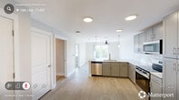 This one-bedroom, one-bathroom unit at 5440 Atlantic Springs Rd in Raleigh, NC offers a thoughtfully designed layout that maximizes its compact footprint. The open-concept kitchen and living area serves as the heart of the unit, featuring light hardwood-style flooring that extends throughout the main living spaces. The kitchen is outfitted with grey shaker-style cabinetry, white subway tile backsplash, light stone countertops, and a full suite of stainless steel appliances, including a refrigerator, electric range, built-in microwave, and dishwasher. Recessed lighting and pendant fixtures illuminate the space effectively.

A hallway connects the main living area to the bedroom and bathroom, with the bathroom showcasing matching grey cabinetry, granite-style countertops, and a built-in linen tower for additional storage. The bedroom offers a comfortable, well-proportioned space with plush wall-to-wall carpeting, a ceiling fan with integrated lighting, a standard closet, and a window that allows natural light to enter. The unit's neutral color palette and consistent modern finishes throughout create a clean, cohesive aesthetic.