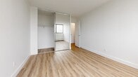 Located at 120 Torresdale Ave in Toronto's North York neighbourhood, this well-appointed 3-bedroom, 1-bathroom unit offers a clean, modern aesthetic across a comfortable single floor. Light wood laminate flooring runs throughout, complementing the crisp white walls and creating a bright, cohesive feel.

The living room is a generously sized open area with large floor-to-ceiling windows framing tree-lined outdoor views, along with baseboard heating beneath the sills. The layout connects naturally to the hallway and adjacent rooms.

The kitchen is thoughtfully designed with white shaker-style cabinetry, grey countertops, a subway tile backsplash, stainless steel appliances including a refrigerator and dishwasher, and a double-basin sink — offering both style and functionality.

Each of the three bedrooms features the same light wood flooring and neutral white walls. The primary and secondary bedrooms include sliding mirrored closet doors with built-in shelving, while large windows provide natural light and treetop views. The third bedroom is a quieter interior-facing room with easy hallway access.

The bathroom is finished in an all-white palette with subway tile surround, a soaker tub with shower, a vanity with a white countertop, and a large mirror — clean and functional in design.

The hallway connects all rooms efficiently, completing this well-organized and move-in-ready unit.