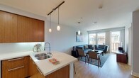 Located at 33 San Pablo Ave in San Rafael, California, this contemporary single-floor residence offers a thoughtfully designed open-concept layout with modern finishes throughout. The living and dining area flows seamlessly from the kitchen, featuring light hardwood flooring, neutral tones, and large windows that invite abundant natural light and views of the surrounding neighborhood. The kitchen is a standout feature, equipped with rich warm-toned wood cabinetry, white quartz countertops, stainless steel appliances including a professional-grade gas range with overhead hood, a French door refrigerator, and an undermount double sink — all designed for both functionality and style. The spacious primary bedroom is carpeted for comfort and opens directly onto a private balcony through sliding glass doors, offering outdoor views and natural light. A second bedroom provides a cozy retreat with neutral walls and ample space. The bathroom is finished with large-format tile, a glass-enclosed shower, a soaking tub, and a sleek wood-and-white vanity. Additional conveniences include an in-unit stacked washer and dryer. The overall ambiance is clean, modern, and comfortable, making this a well-equipped and inviting urban residence.