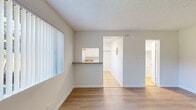 Located at 8919 Longden Ave in Temple City, California, this one-bedroom, one-bathroom unit offers a practical and well-organized single-floor layout. The living area is bright and open, featuring wood-look laminate flooring and a large window fitted with vertical blinds that invite generous natural light and views of outdoor greenery. A wall-mounted air conditioning unit provides climate control, and a textured popcorn ceiling adds a classic residential character throughout.

The kitchen is accessible via a convenient pass-through window with a built-in counter ledge, as well as a direct entryway. It is equipped with white cabinetry, a double-basin sink, earthy laminate countertops, a gas range with overhead ventilation, and a window that fills the space with additional natural light. Tile flooring grounds the kitchen area cleanly.

The spacious primary bedroom offers ample room for furnishings, continuing the wood-look flooring found in the living area. It connects to a dedicated closet, providing practical storage. The bathroom features a white vanity with under-cabinet storage, a mirrored medicine cabinet, tile flooring, and clean white walls, creating a simple and functional space.

Overall, the unit presents a clean, neutral aesthetic with a cohesive color palette of whites and soft grays, making it a versatile and move-in ready space in a residential Temple City neighborhood.