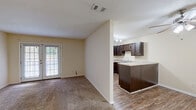 This single-floor, 2-bedroom, 3-bathroom home in Phenix City, Alabama offers a functional and well-organized layout. The living room is generously proportioned, featuring plush carpet flooring, a ceiling fan, and a door that invites natural light from outside. It connects seamlessly to the dining area and kitchen, creating an open and sociable flow. The kitchen is a standout feature, equipped with rich dark-wood cabinetry, light countertops, a double-basin sink, a dishwasher, a range, and a refrigerator. Track lighting overhead and a peninsula-style breakfast bar add both practicality and style. Hardwood-style flooring runs through the kitchen and hallways, complementing the warm, neutral tones found throughout the home. Two hallways connect the various rooms efficiently, with three closets providing ample storage. The bedrooms are carpeted and include ceiling fans and closets with built-in rods. The primary bedroom features its own access to a bathroom and dedicated closet space. Three bathrooms serve the home, each featuring clean, simple finishes and hardwood-style flooring. A dedicated laundry room adds everyday convenience. Textured ceilings are present throughout, contributing to the home's classic, comfortable character.
