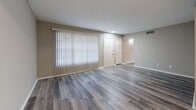 Located at 6300 Old Canton Rd in Jackson, Mississippi, this single-floor unit offers a well-organized layout with a clean, neutral aesthetic throughout. The living area features light-toned luxury vinyl plank flooring and large vertical blinds that allow for adjustable natural light, creating an open and airy feel. The galley-style kitchen is well-appointed with white cabinetry, granite-look countertops, stainless steel appliances including a refrigerator and dishwasher, and a double-basin sink — all complemented by matching LVP flooring that flows seamlessly into the adjacent dining area. The bedrooms are generously proportioned, each finished with plush carpeting, ceiling fans with light fixtures, and windows fitted with horizontal blinds that provide both privacy and natural light. The bathrooms are finished consistently, each featuring wood-look LVP flooring, a tub-shower combination with white tile surround, and a vanity with granite-look countertops and white cabinetry. The overall design maintains a cohesive, neutral color palette of warm beiges and soft grays, giving the space a clean and move-in ready appearance throughout.