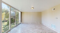 Located in Lafayette, CA, this single-floor space offers a well-organized layout with a variety of functional areas throughout. The main living area makes a strong impression with large floor-to-ceiling windows that invite an abundance of natural light and frame lush greenery views. Polished marble-look tile flooring extends across the living and entry areas, lending a clean and refined aesthetic, while warm neutral-toned walls create a calm, cohesive atmosphere throughout.

The kitchen is equipped with warm honey-toned wood cabinetry, granite countertops, a stainless steel range hood, and a electric range with ample counter space and a sink — providing a practical and inviting cooking environment. The bedrooms feature plush carpeting and windows overlooking greenery, offering a comfortable and quiet retreat. One room benefits from a sliding glass panel entry that diffuses soft, natural light into the space.

The bathroom is finished with travertine-style tile walls, a combined soaking tub and shower enclosed by a sleek glass sliding door, and a window providing natural ventilation. Additional features include a visible electrical panel, HVAC vents, and a translucent glass sliding entry door that adds architectural interest. Overall, this space balances practicality with natural charm in a desirable Northern California setting.