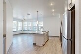 Located at 1050 Beckoning Blvd in Charlotte, NC, this thoughtfully designed single-floor residence offers two bedrooms and two bathrooms within a comfortable and efficiently laid-out floor plan. The open-concept kitchen and living area serves as the heart of the home, anchored by a large center island with granite countertops, an integrated sink, and elegant pendant lighting. Gray shaker-style cabinetry, a subway tile backsplash, and stainless steel appliances complete the kitchen. Light wood-look flooring flows throughout the main living areas, complementing the bright, neutral palette. A bank of large windows floods the living room with natural light and provides views of the surrounding neighborhood, while a ceiling fan adds comfort overhead. Both bedrooms feature plush carpeting and generous windows, with the primary bedroom offering a walk-in closet equipped with wire shelving. The two bathrooms are finished with gray cabinetry, granite vanity tops, and clean tile flooring, with one featuring a tub-shower combination. Additional highlights include a dedicated laundry area, a patio for outdoor enjoyment, a hallway with built-in shelving and cabinetry, and ample closet storage throughout.