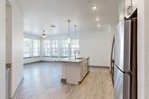 Located at 1050 Beckoning Blvd in Charlotte, NC, this thoughtfully designed single-floor residence offers two bedrooms and two bathrooms within a comfortable and efficiently laid-out floor plan. The open-concept kitchen and living area serves as the heart of the home, anchored by a large center island with granite countertops, an integrated sink, and elegant pendant lighting. Gray shaker-style cabinetry, a subway tile backsplash, and stainless steel appliances complete the kitchen. Light wood-look flooring flows throughout the main living areas, complementing the bright, neutral palette. A bank of large windows floods the living room with natural light and provides views of the surrounding neighborhood, while a ceiling fan adds comfort overhead. Both bedrooms feature plush carpeting and generous windows, with the primary bedroom offering a walk-in closet equipped with wire shelving. The two bathrooms are finished with gray cabinetry, granite vanity tops, and clean tile flooring, with one featuring a tub-shower combination. Additional highlights include a dedicated laundry area, a patio for outdoor enjoyment, a hallway with built-in shelving and cabinetry, and ample closet storage throughout.
