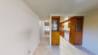 This two-story, 2-bedroom, 2.5-bathroom residence offers a well-organized layout designed for comfortable everyday living. The kitchen is a functional highlight, featuring warm honey-toned wood cabinetry with ample storage, granite-style countertops, a double sink, and white appliances including a range, oven, refrigerator, and dishwasher. Light tile flooring flows throughout the kitchen and into the adjacent hallway, which opens toward a bright living area with views to an outdoor space.

Both bedrooms are generously sized and finished with plush carpet. Each offers natural light through large windows or sliding glass doors that lead to private outdoor areas, providing pleasant greenery views. The bedrooms are equipped with baseboard heating and wall-mounted air conditioning units for year-round comfort. One bedroom features a built-in vanity with a marble-style countertop and large mirror, accompanied by a spacious sliding-door closet.

The bathrooms are clean and well-appointed. The full baths include a tub and shower combination with sliding glass doors, while the half bath features a marble-accented vanity, sink, and mirror. Textured ceilings are consistent throughout the home, contributing to its classic character. The layout across two floors provides a practical separation of living and sleeping spaces.