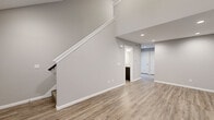 Located at 3115 Carroll Rd in Fort Wayne, Indiana, this two-story home offers a thoughtfully designed layout spread across two floors. The main level features a welcoming living room with vaulted ceilings, recessed lighting, a ceiling fan, and luxury vinyl plank flooring that extends throughout. A bright window allows natural light to fill the space, enhancing its open and airy feel. The kitchen is a standout feature, showcasing dark cabinetry, granite countertops, stainless steel appliances including a refrigerator, range, microwave, and dishwasher, all complemented by continued LVP flooring. A back door provides convenient outdoor access. The lower level includes a spacious hallway, an additional bathroom with a dark vanity and granite countertop, and access to the staircase. Upstairs, the two bedrooms are carpeted and generously sized, with the primary bedroom offering a walk-in closet. The bathrooms are finished consistently with dark vanities, granite countertops, and clean white tub-shower combinations. Neutral gray walls and white trim throughout the home create a cohesive, modern aesthetic that is both clean and inviting.