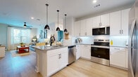 Located at 34 Ramsey Branch Rd in Freeport, FL, this single-story residence offers 2 bedrooms, 2 bathrooms, and a thoughtfully designed open-concept floor plan. The kitchen serves as the centerpiece of the main living area, showcasing white shaker cabinetry, granite countertops, a herringbone tile backsplash, stainless steel appliances, and a large island with seating for three — illuminated by a trio of black pendant lights. The kitchen flows seamlessly into a bright, airy living room featuring light hardwood flooring, a ceiling fan, and generous windows that invite abundant natural light. Both bedrooms are comfortably sized, each with large windows offering outdoor views, light wood flooring, and ample closet space. The primary bathroom includes a granite-topped vanity, a walk-in glass shower, and direct access to a walk-in closet. Additional highlights include four closets, an in-unit laundry space, and a clean, neutral color palette throughout. The overall ambiance is modern and welcoming, with consistent use of black hardware accents, wood tones, and crisp white walls creating a cohesive, contemporary aesthetic well-suited to the Florida lifestyle.