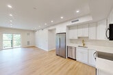 Located at 499 Atkinson Ave in Stoughton, MA, this well-appointed 3-bedroom, 3-bathroom unit offers a thoughtfully designed single-floor layout. The open-concept kitchen and living area serves as the heart of the home, featuring crisp white shaker cabinetry with gold hardware, stainless steel appliances including a refrigerator, range, microwave, and dishwasher, light wood-look flooring, and recessed lighting throughout. The seamless flow between kitchen and living space creates an airy, functional environment ideal for everyday living and entertaining.

The spacious primary bedroom receives generous natural light through a large picture window overlooking lush greenery, and connects to a private bathroom. Each bedroom is finished with the same warm hardwood-style flooring and neutral tones. The bathrooms are clean and modern, featuring white vanities with gold-accented hardware, walk-in showers, and a combination tub/shower unit. An in-unit stacked washer and dryer adds everyday convenience.

Throughout the unit, a consistent palette of soft neutral walls and light flooring creates a bright, cohesive ambiance. A private balcony offers peaceful views of surrounding trees and open landscape, completing this well-designed and move-in-ready residence.