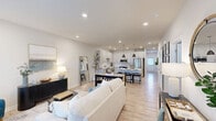This single-story residence in Port Wentworth, Georgia offers a thoughtfully designed layout with two bedrooms, two bathrooms, a combined kitchen and living area, a dedicated laundry room, two closets, and a hallway connecting the spaces seamlessly. The open living room is bright and welcoming, featuring light wood-style flooring, recessed lighting, and large windows dressed with sheer curtains that allow abundant natural light to fill the space. The kitchen is a standout, outfitted with white shaker-style cabinetry, white quartz countertops, a subway tile backsplash, stainless steel appliances including a refrigerator and dishwasher, and ample storage throughout. Both bedrooms are comfortably sized, each featuring ceiling fans, large windows with exterior views, and a calm, neutral palette. The primary bathroom includes a glass-enclosed walk-in shower and a single vanity, while the second bathroom offers a full shower-tub combination. The in-unit laundry room provides added convenience with space for a full-size washer and dryer alongside overhead shelving. Light wood-style flooring runs throughout the home, tying the clean, modern aesthetic together cohesively.