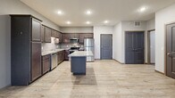 Located at 1160 Suncrest Dr in Saint Cloud, MN, this single-floor, one-bedroom, one-bathroom unit offers a well-planned layout across a comfortable footprint. The kitchen is a standout feature, showcasing rich dark-wood cabinetry extending to the ceiling, granite countertops, a central island with additional counter space, and a full suite of stainless steel appliances including a refrigerator, range, microwave, and dishwasher. Light hardwood-style flooring runs throughout the kitchen and entry areas, creating a clean transition into the living room. The spacious living room is carpeted and bathed in natural light, with a sliding door leading to a private balcony and a wall-mounted HVAC unit for climate control. Baseboard heating is present throughout the unit. The generously sized primary bedroom features plush carpeting, a large window with outdoor views, and ample wall space for furnishings. The bathroom is well-appointed with dark wood vanity cabinetry, a wide vanity mirror, stylish light fixture, solid-surface countertop, and stone-look tile flooring. A dedicated closet and hallway complete the layout, offering practical storage and connectivity between rooms. Neutral gray walls and recessed lighting lend the space a modern, move-in-ready feel.