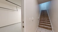 This two-story home offers a thoughtfully designed layout spread across two levels, connected by a carpeted staircase with a white railing. The main living area features warm hardwood flooring that flows seamlessly throughout, complemented by crisp crown molding and a neutral color palette that creates a bright, welcoming ambiance.

The kitchen is well-equipped with white raised-panel cabinetry, light stone countertops, a stainless steel sink, and black appliances including a range, over-the-range microwave, dishwasher, and refrigerator. A peninsula with pendant lighting opens the kitchen to the living and dining areas, enhancing the sense of connected, open-plan living.

The bedrooms are generously proportioned, each finished with hardwood floors, crown molding, and ceiling fans. Natural light fills the rooms through sizable windows, with views of the surrounding neighborhood. Walk-in closets with built-in rod systems provide ample storage.

The bathroom is cleanly finished with a tiled tub-and-shower combination, a quartz-top vanity, and brushed nickel fixtures. An attached garage with overhead lighting and built-in storage racking offers practical convenience. Overall, the home presents a clean, functional, and comfortable living environment with consistent finishes throughout.