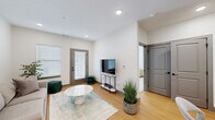 This thoughtfully designed one-bedroom, one-bathroom residence in Olathe, Kansas offers a clean, modern aesthetic throughout its efficiently utilized single-floor layout. The open-concept living area features warm hardwood-style flooring, recessed lighting, and large windows with blinds that allow ample natural light to fill the space. A glass-paneled exterior door provides direct outdoor access, enhancing the sense of openness.

The kitchen is a standout feature, boasting crisp white shaker cabinetry, dark countertops, and a striking herringbone-patterned tile backsplash. Stainless steel appliances — including a refrigerator with ice maker, dishwasher, range, and microwave — complete the space, which also accommodates a dining area with easy access to the living room.

The generously sized primary bedroom offers plush carpeting, a ceiling fan, sheer window treatments that invite soft natural light, and a dedicated closet. The bathroom is finished with large-format marble-look tile on both the floors and walls, paired with a clean white vanity, creating a spa-like atmosphere.

This residence combines contemporary design with functional living spaces, making it a well-appointed home in the Olathe, KS area.