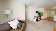 Located at 316 Columbia Dr in Carrollton, GA, this well-appointed unit offers four bedrooms and four bathrooms across a single floor, delivering a comfortable and functional layout. The living room features plush carpeting, a ceiling fan, and a bright window that fills the space with natural light, creating a welcoming atmosphere. The combined kitchen and living area is anchored by warm honey-toned cabinetry, white appliances including a refrigerator, electric range, and over-the-range microwave, along with wood-look flooring that adds a clean, contemporary feel. A dedicated laundry room houses a full-size washer and dryer with overhead wire shelving for added storage convenience. Each of the four bedrooms is carpeted and benefits from windows that invite natural light, offering a calm and comfortable retreat. The bedrooms are generously proportioned, with the primary bedroom providing ample space for furnishings and personal use. All four bathrooms feature tub-shower combinations with tiled surrounds, curtain rods, and neutral warm-toned walls, maintaining a clean and consistent aesthetic throughout. The overall color palette of soft creams and beiges lends the unit a bright, cohesive ambiance suited for comfortable everyday living.