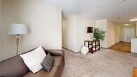 Located at 316 Columbia Dr in Carrollton, GA, this well-appointed unit offers four bedrooms and four bathrooms across a single floor, delivering a comfortable and functional layout. The living room features plush carpeting, a ceiling fan, and a bright window that fills the space with natural light, creating a welcoming atmosphere. The combined kitchen and living area is anchored by warm honey-toned cabinetry, white appliances including a refrigerator, electric range, and over-the-range microwave, along with wood-look flooring that adds a clean, contemporary feel. A dedicated laundry room houses a full-size washer and dryer with overhead wire shelving for added storage convenience. Each of the four bedrooms is carpeted and benefits from windows that invite natural light, offering a calm and comfortable retreat. The bedrooms are generously proportioned, with the primary bedroom providing ample space for furnishings and personal use. All four bathrooms feature tub-shower combinations with tiled surrounds, curtain rods, and neutral warm-toned walls, maintaining a clean and consistent aesthetic throughout. The overall color palette of soft creams and beiges lends the unit a bright, cohesive ambiance suited for comfortable everyday living.
