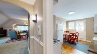 Located in Buffalo's historic West Side, this well-maintained 2-bedroom, 1-bathroom residence offers a thoughtful layout with classic architectural character throughout. The expansive living room features vaulted ceilings with angled rooflines, plush carpeting, a fireplace, and a charming arched window nook—creating a warm and inviting atmosphere. A elegant chandelier and radiator heating add to the home's vintage character.

The kitchen is efficiently designed with white cabinetry, subway tile backsplash, stone-look countertops, hardwood flooring, and full appliances including a gas range and refrigerator. It opens directly into a bright dining area with natural light from multiple windows and a door providing exterior access.

The primary bedroom offers vaulted ceiling details, hardwood floors, and natural light from a side window. The second bedroom features soft carpeting, yellow-toned walls, a closet, and includes a convenient stacked washer and dryer. The full bathroom is neatly appointed with tile flooring and a walk-in shower.

Two hallways connect the spaces efficiently, and a wall-mounted intercom system adds a functional touch. The home's blend of classic detailing and practical amenities makes it a distinctive offering in the Buffalo market.