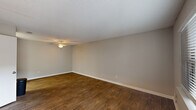 Located at 2310 W Cameo Ln in Knightdale, NC, this single-floor, 2-bedroom, 2-bathroom home offers a practical and well-appointed layout. The living room features rich, dark wood-style flooring, neutral gray walls, a textured ceiling, and a ceiling fan, creating a comfortable and welcoming atmosphere. Natural light flows in through windows fitted with blinds throughout the home.

The kitchen is a functional galley-style space outfitted with white shaker cabinets, granite-look countertops, a stainless steel sink, and stainless steel appliances including a range and refrigerator, complemented by light wood-style flooring.

Both bedrooms are carpeted with neutral tones and include windows that bring in natural light. The primary bedroom features a walk-in closet with built-in shelving. The second bedroom also offers closet access and a similarly comfortable feel.

The two bathrooms are clean and efficiently designed. One includes a single-sink vanity with white cabinetry, a framed mirror, and wood-style flooring. The second bathroom features a tub/shower combination with a curtain rod and light wood-style flooring. A hallway with additional closet storage connects the main areas of the home. The entry foyer, with its bold black front door, sets a welcoming tone upon arrival.