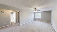 Located at 205 Arthur Dr in Thomasville, NC, this single-floor unit offers a practical and comfortable layout with 2 bedrooms and 2 bathrooms. The interior is finished with neutral gray walls and textured ceilings throughout, creating a consistent and clean aesthetic.

Both bedrooms are carpeted and feature ceiling fans with integrated lighting, offering comfort year-round. Each room includes a window that allows natural light and views of the surrounding greenery. The primary bedroom is generously sized and includes a double-door closet for ample storage. The second bedroom similarly includes a closet with bifold doors.

The two bathrooms are outfitted with wood-look tile flooring. One bathroom includes a walk-in shower with built-in shelving, while the other features a full bathtub and shower combination with chrome fixtures.

The kitchen is equipped with light wood cabinetry, a black gas range, a black refrigerator, and a double sink positioned beneath a window. Light laminate flooring ties the kitchen together for easy maintenance.

A dedicated closet with shelving and a washer/dryer hookup adds everyday convenience. A connecting hallway links the main living areas, completing this well-organized and functional home.