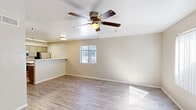 Located in Tempe, Arizona, this single-floor, one-bedroom, one-bathroom unit offers a thoughtfully designed layout that makes efficient use of its space. The open-concept living, dining, and kitchen area forms the heart of the home, featuring light wood-look flooring throughout and a ceiling fan with integrated lighting that keeps the space comfortable and well-lit. A window brings in natural light and provides a view to the outdoors, enhancing the airy feel of the main living area.

The kitchen is appointed with a peninsula breakfast bar, stainless steel appliances including a refrigerator, microwave, and range, along with taupe cabinetry and clean white countertops. A double-basin sink and dishwasher add everyday convenience.

The bedroom is a comfortable size, featuring its own ceiling fan, sliding glass door access to an outdoor space, and a large walk-in closet outfitted with built-in shelving and dual hanging rods — ideal for organized storage.

The bathroom offers a full tub-shower combination, a grey vanity with a white countertop, a mirror, and stylish brushed nickel fixtures. Wood-look flooring continues here, tying the design together cohesively. A dedicated laundry area and a hallway complete the functional floor plan of this well-appointed Tempe residence.
