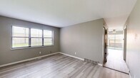 Located at 6698 Amora Avenue in Berkeley, Missouri, this three-bedroom, two-bathroom home spans three floors, offering a well-distributed layout across each level. The main floor sets the tone with a living room and kitchen, the latter featuring gray cabinetry with sleek black hardware, dark speckled granite-style countertops, and light wood-look flooring that carries through much of the upper levels. The bedrooms are comfortably sized, with the carpeted secondary bedrooms each benefiting from natural light through blinded windows. The primary bedroom is notably spacious and includes sliding glass doors that open to a private outdoor patio area, complemented by a ceiling fan overhead. The bathrooms mirror the kitchen's design palette, featuring matching gray vanities with granite-style counters and light flooring. Two staircases connect the floors, providing practical circulation throughout the home. The unfinished basement level, with its concrete walls, painted floors, and exposed overhead structure, presents significant potential for storage or future customization. Overall, the home presents a clean, neutral aesthetic with updated finishes and functional layouts across all three levels.