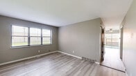 Located at 6698 Amora Avenue in Berkeley, Missouri, this three-bedroom, two-bathroom home spans three floors, offering a well-distributed layout across each level. The main floor sets the tone with a living room and kitchen, the latter featuring gray cabinetry with sleek black hardware, dark speckled granite-style countertops, and light wood-look flooring that carries through much of the upper levels. The bedrooms are comfortably sized, with the carpeted secondary bedrooms each benefiting from natural light through blinded windows. The primary bedroom is notably spacious and includes sliding glass doors that open to a private outdoor patio area, complemented by a ceiling fan overhead. The bathrooms mirror the kitchen's design palette, featuring matching gray vanities with granite-style counters and light flooring. Two staircases connect the floors, providing practical circulation throughout the home. The unfinished basement level, with its concrete walls, painted floors, and exposed overhead structure, presents significant potential for storage or future customization. Overall, the home presents a clean, neutral aesthetic with updated finishes and functional layouts across all three levels.