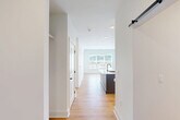 Located at 430 Manufacturers Rd in Chattanooga, TN, this thoughtfully designed one-bedroom, one-bathroom residence offers an efficient and contemporary single-floor layout. Warm hardwood flooring flows throughout the entire unit, tying together a clean, modern aesthetic defined by crisp white walls and black hardware accents.

The open-concept kitchen and living area serves as the heart of the home. The kitchen is outfitted with full-height white shaker cabinetry featuring gold hardware, a full suite of stainless steel appliances including a French door refrigerator, range, and microwave, and a generous island with a quartz countertop and an undermount sink with a matte black faucet — ideal for both cooking and casual dining.

The bathroom stands out with its distinctive navy blue vanity, white quartz countertop, and large mirror, lending a bold, designer touch. A sliding barn door and panel-style interior doors with black hardware add to the modern character throughout the unit.

The bedroom benefits from natural light through a window with scenic outdoor views. A spacious walk-in closet with multi-tiered wire shelving provides ample storage. A dedicated office space adds functional versatility, while the entrance opens into a well-organized layout that maximizes every square foot of this efficiently designed Chattanooga residence.