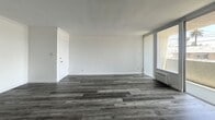 This 530-square-foot, 1-bedroom, 1-bathroom apartment at 1840 Winona Blvd in Los Angeles' Los Feliz neighborhood offers a thoughtfully updated interior with modern finishes throughout. The open-concept living and kitchen area is anchored by durable gray wood-look flooring and crisp white walls accented with crown molding. The living room features large sliding glass doors that open to a private balcony, filling the space with natural light and offering neighborhood views of surrounding palm trees. The kitchen is well-appointed with white shaker cabinets, a quartz countertop peninsula, subway tile backsplash, and a full suite of stainless steel appliances including a refrigerator, range, microwave, and dishwasher. The 110-square-foot bedroom includes a closet and a high horizontal window that brings in additional natural light while maintaining privacy. Wall-unit air conditioners provide climate control throughout the unit. The bathroom features a full soaking tub with an overhead shower, white subway tile surround reaching to the ceiling, a gray vanity with a white basin, and brushed nickel fixtures. Crown molding is present throughout, lending a polished, cohesive aesthetic to the entire unit.