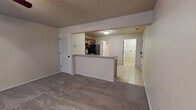 Located at 1950 South Scenic Avenue in Springfield, Missouri, this single-floor unit offers a practical and well-organized layout designed for comfortable everyday living. The open-concept living area features neutral-toned carpet and a ceiling fan with integrated lighting, creating a relaxed and functional atmosphere. A half-wall peninsula seamlessly connects the living space to the kitchen, providing an ideal pass-through for dining and entertaining. The kitchen is well-appointed with rich wood cabinetry, light countertops, and a full suite of black appliances including a refrigerator, electric range, built-in microwave, and dishwasher. Light tile flooring runs throughout the kitchen and utility areas, offering durability and easy maintenance. A dedicated laundry room includes washer and dryer hookups along with overhead shelving for additional storage, and is conveniently located alongside the electrical panel. The bathroom features tile flooring, a double-sink vanity with warm wood cabinetry, and a separate water closet area. Throughout the unit, neutral wall tones and clean white trim create a cohesive and move-in-ready aesthetic. A louvered closet door in the living area and hallway access to additional rooms further enhance the unit's functional design.