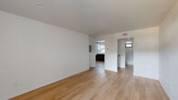 This efficiently designed 1-bedroom, 1-bathroom single-floor residence offers a clean, modern aesthetic throughout. Light-toned hardwood flooring flows continuously across the open living and dining area, creating a bright and cohesive feel. The combined living and dining space is open and airy, with crisp white walls and recessed lighting that maximize the sense of space.

The kitchen is thoughtfully appointed with a two-tone cabinet design — white upper cabinets paired with dark lower cabinets — accented by white subway tile backsplash and light countertops. Stainless steel appliances, including a range, dishwasher, and over-the-range microwave, complete the functional layout. A window above the sink brings in natural light.

The bedroom is a comfortable, well-proportioned room featuring a ceiling fan, a window with blinds for natural light and privacy, and direct access to a dedicated closet. The bathroom includes a full tub-and-shower combination with large-format white tile surround and gold-tone fixtures, complemented by a frosted window for natural light.

Additional features include a pantry, a laundry area, and ample storage via a dedicated closet. The overall design is clean and contemporary, with a consistent white-and-wood palette throughout.