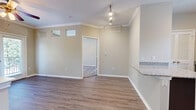 This thoughtfully designed single-floor residence offers a functional and cohesive layout across its 1 bedroom, 1 bathroom, and key living spaces. The living room features hardwood-style flooring, crown molding, a ceiling fan, and a private exterior door that brings in natural light and outdoor views through large windows. Transom windows add an architectural touch to the interior, enhancing the sense of openness.

The kitchen is a standout feature, outfitted with rich dark-toned cabinetry, granite countertops, a decorative tile backsplash, and a full suite of stainless steel appliances including a refrigerator, range, microwave, and dishwasher. A peninsula with a granite overhang provides additional prep space and a casual seating area, seamlessly connecting the kitchen to the living space.

The bedroom is carpeted, with multiple windows offering greenery views and a ceiling fan for added comfort. The bathroom continues the design language with a granite-topped dark vanity, a large mirror with lighted fixtures, and a soaking tub. A dedicated closet with built-in shelving and carpeted flooring provides practical storage. Hardwood-style flooring carries through the main areas, unifying the home's clean, modern aesthetic.