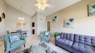 Located in Houston, TX, this two-story home offers a well-designed layout across two floors, providing comfortable living for residents. The main floor features a bright, tile-floored living room with crown molding, a ceiling fan, and natural light from a front-facing window — ideal for relaxing or entertaining. Adjacent to the living room, the dining area impresses with a chandelier, built-in shelving, wainscoting, and a pass-through window connecting directly to the kitchen. The galley-style kitchen is equipped with dark cabinetry, granite countertops, a stone tile backsplash, and black appliances. Three full bathrooms are distributed throughout the home, each featuring granite-topped vanities and tub-shower combinations. Upstairs, the three bedrooms are carpeted and outfitted with ceiling fans. The spacious primary bedroom features vaulted ceilings and an open closet with built-in shelving, offering generous storage. Additional highlights include two staircases, hallways connecting key areas, a dedicated laundry space, and a balcony for outdoor enjoyment. The home's neutral color palette and consistent finishes create a cohesive and functional living environment throughout.