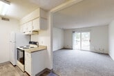 Located at 2405 Beverly Dr in Urbandale, Iowa, this one-bedroom, one-bathroom unit delivers a functional and well-organized single-floor layout. The living room is a standout space, featuring plush carpet, neutral white walls, a textured ceiling, and a sliding glass door that fills the room with natural light and provides direct access to the outdoors. Adjacent to the living room, the combined kitchen and dining area transitions to hard surface flooring and includes white cabinetry, overhead storage, a range with hood, and a countertop workspace — offering an efficient setup for everyday cooking and dining. A hallway connects the main living areas to the private bedroom, which is a generously sized retreat with carpet flooring, a large window overlooking the exterior greenery, and access to three closets throughout the unit for ample storage. The full bathroom is appointed with a tiled shower-tub combination, a vanity with a light stone-patterned countertop, and wood-look flooring. A utility room rounds out the layout, adding practical functionality. Throughout the unit, a consistent neutral color palette and textured ceilings create a clean, understated aesthetic.
