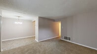 Located at 3111 S Leonard Springs Rd in Bloomington, Indiana, this 2-bedroom, 1-bathroom single-floor unit offers a straightforward and functional layout. The living room features neutral taupe walls, wall-to-wall carpet, and multiple windows that bring in natural light. A chandelier overhead marks the transition into the adjoining dining area, and a louvered closet near the entry provides convenient storage.

The kitchen is equipped with warm wood cabinetry spanning floor to ceiling, laminate countertops, a double-basin sink, a black refrigerator, and a black gas range, all set on durable tile flooring. A ceiling vent ensures proper ventilation throughout.

Both bedrooms are carpeted and finished with the same neutral tones seen throughout the unit. The primary bedroom is generously sized and features a built-in closet with louvered bifold doors, a window for natural light, and direct access to the hallway. The second bedroom also includes a window with exterior views.

The bathroom offers a full tub-shower combination with white tile surround, a wood-toned vanity with an integrated sink, and matching tile flooring. A wall-mounted medicine cabinet adds practical storage. Throughout the unit, textured ceilings and clean white baseboards contribute to a cohesive, functional aesthetic.
