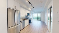 Located at 2215 Sheridan Park Drive in Mississauga, this well-appointed one-bedroom, one-bathroom unit offers a thoughtfully designed open-concept layout with modern finishes throughout. Light hardwood-style flooring runs continuously across the living areas, enhancing the sense of openness and warmth.

The kitchen is sleek and functional, featuring crisp white cabinetry, stainless steel appliances including a refrigerator, dishwasher, over-the-range microwave, and electric range, complemented by a stainless steel countertop and backsplash. Track lighting overhead adds a contemporary touch.

The open living area flows seamlessly toward floor-to-ceiling sliding glass doors that lead to a private balcony, allowing abundant natural light to fill the space and offering outdoor views of the surrounding area.

The bedroom is a comfortable retreat with large sliding glass doors providing balcony access, light-toned flooring, and a built-in closet with full-panel sliding doors for ample storage.

The bathroom is clean and modern, finished with large-format tile flooring, white subway-tiled walls, a soaker tub with a handheld shower fixture, and a wood-toned vanity with a white countertop, creating a calm, spa-like atmosphere.