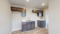 Located at 607 Woodbury Hwy in Manchester, Tennessee, this single-story, 3-bedroom, 1-bathroom home offers a clean, functional layout with a cohesive neutral aesthetic throughout. Light wood-look luxury vinyl flooring runs continuously across all rooms, complemented by soft greige wall tones and crisp white trim, creating a bright and cohesive interior.

The living room welcomes natural light through large front-facing windows flanking a paneled entry door with a decorative transom window above, providing an open and airy feel. The kitchen features dark slate-toned shaker-style cabinetry with matching upper cabinets, a double-basin sink, light countertops, and recessed lighting — offering ample storage and prep space in a compact, efficient design.

The three bedrooms are well-proportioned, with the primary bedroom providing a comfortable footprint. Each room benefits from natural light via double windows with blinds, and all share the same consistent flooring and neutral wall palette. One bedroom includes access to the electrical panel near the entrance.

The full bathroom is neatly appointed with a dark vanity cabinet, white countertop, toilet, and a full tub-shower combination with white surround. A central hallway connects all rooms, ensuring smooth flow throughout. This home presents a move-in ready interior with clean finishes throughout.