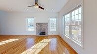 Located at 1148 Meagan Ct in Elgin, Illinois, this multi-story home spans three floors and offers a thoughtfully designed layout with a range of functional and recreational spaces. The main level features warm hardwood flooring throughout, beginning with an open living area anchored by a wood-railed staircase that draws in natural light from above. A bright dining area showcases large sliding glass doors leading to an outdoor patio, flooding the space with sunlight. The kitchen is well-appointed with rich wood cabinetry, granite countertops, a central island, stainless steel appliances, and recessed lighting. Upper-level bedrooms are generously proportioned, each featuring hardwood floors, large windows with neighborhood views, and ceiling fans. A walk-in closet with custom built-in shelving, hanging rods, and integrated drawers provides substantial storage. Bathrooms throughout are finished with tile flooring and clean white fixtures accented by brushed gold hardware. A dedicated laundry room houses side-by-side front-load washer and dryer units with overhead shelving. The lower level includes a private home theater room equipped with a ceiling-mounted projector and tiered leather recliner seating, making it an ideal entertainment retreat.